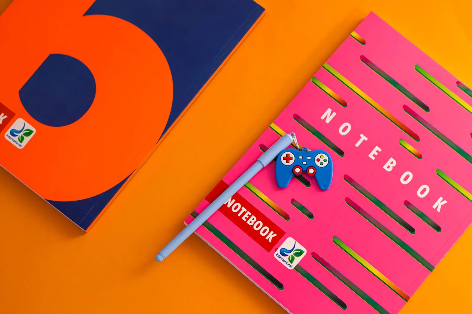 Útiles escolares de colores sobre fondo naranja (fotografía ilustrativa)